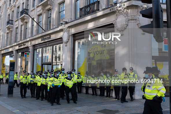 LONDON, UNITED KINGDOM - AUGUST 25, 2021: Large group of police officers prepare to remove environmental activists from Extinction Rebellion...
