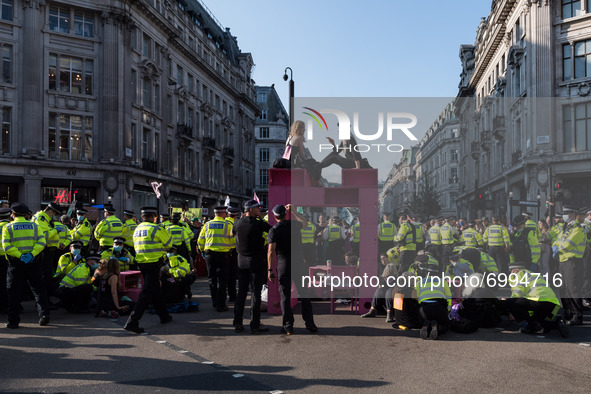 LONDON, UNITED KINGDOM - AUGUST 25, 2021: Police officers cordon off Oxford Circus as environmental activists from Extinction Rebellion are...