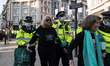 LONDON, UNITED KINGDOM - AUGUST 25, 2021: Police officers lead away two senior protesters...