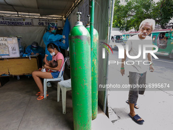 A man peeks at the triage area of a hospital placed along a main road in Manila City, Philippines on August 26, 2021. At least two more hosp...
