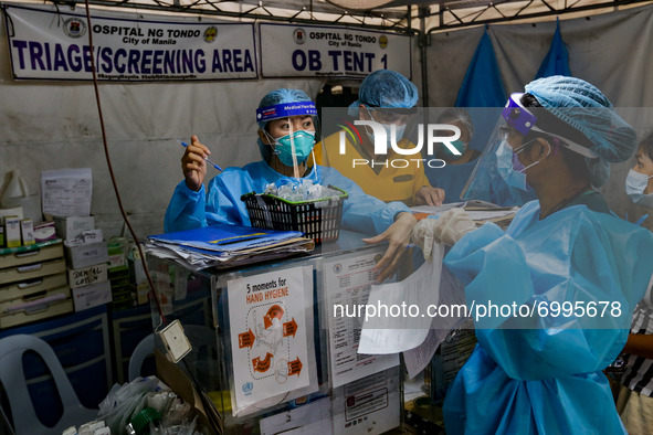 Health workers man the triage area of a hospital placed along a main road in Manila City, Philippines on August 26, 2021. At least two more...