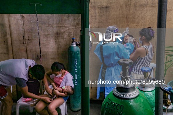 A health worker attempts to conduct a confirmatory swab test to a non-COVID19 patient at the triage area of a hospital in Manila City, Phili...