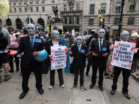 LONDON, UNITED KINGDOM - AUGUST 27, 2021: A group of environmental activists from Extinction Rebellion wearing masks and fake-blood stained...