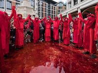LONDON, UNITED KINGDOM - AUGUST 27, 2021: Extinction Rebellion's Red Brigade stad in a pool of fake blood spilled in Paternoster Square afte...