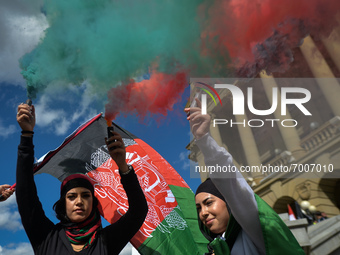 Protesters light flares in the colors of Afghanistan.
Members of the local Afghan diaspora, activists and local supporters seen in front of...