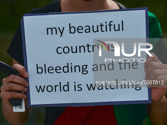 A protester holds a placard that reads 'My beautiful country is bleeding and the world is watching'.
Members of the local Afghan diaspora, a...