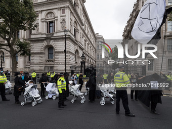 LONDON, UNITED KINGDOM - AUGUST 31, 2021: Activists from Extinction Rebellion block the entrance to Downing Street during a funeral march wi...