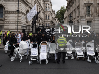 LONDON, UNITED KINGDOM - AUGUST 31, 2021: Activists from Extinction Rebellion block the entrance to Downing Street during a funeral march wi...