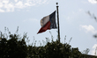 The Texas flag flies above City Hall as demonstrators recite feminist chants in protest of...