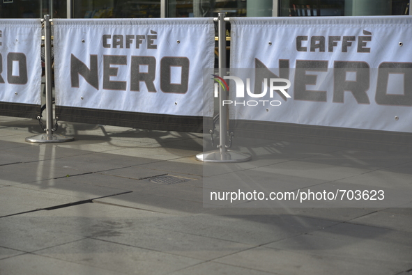 Sunlight, on Friday 24th July 2015, reflecting off the metallic poles, on to the ground, holding small banners which show the Cafe Nero logo...
