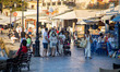 Locals and tourists are seen with facemask walking at the waterfront promenade of the old...