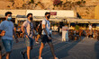 Locals and tourists are seen with facemask walking at the waterfront promenade of the old...