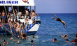 Tourists enjoy a summer evening at Xigia beach as a boat with other tourists approaches in...