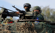 Taiwanese soldiers are seen holding grenade launchers and machine guns and driving tanks,...