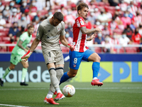Unai Simon of Athletic Club in action with Antoine Griezmann of Atletico de Madrid during the La Liga match between Atletico de Madrid and A...