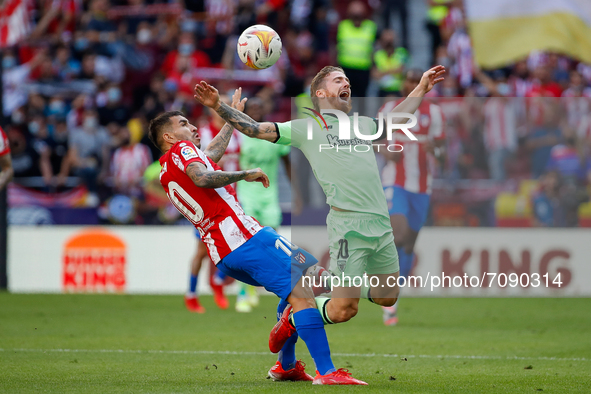 Angel Correa of Atletico de Madrid in action with Iker Muniain of Athletic Club during the La Liga match between Atletico de Madrid and Athl...