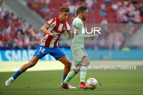 Iker Muniain of Athletic Club in action with Marcos Llorente of Atletico de Madrid during the La Liga match between Atletico de Madrid and A...