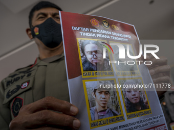 Central Sulawesi Regional Police Chief Inspector General Rudy Sufahriadi shows photos of the four remaining members of the Poso East Indones...