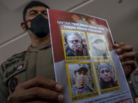 Central Sulawesi Regional Police Chief Inspector General Rudy Sufahriadi shows photos of the four remaining members of the Poso East Indones...