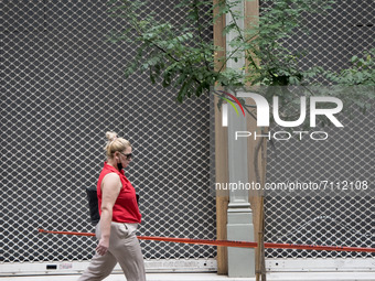 A woman is walking front of a closed shop in the center of Athens, Greece on September 22, 2021. (