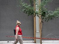A woman is walking front of a closed shop in the center of Athens, Greece on September 22, 2021. (