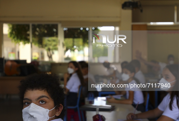 A student wearing a protective mask looks out a window while attending a class at a high school in Limassol. Cyprus, Thursday, September 23,...