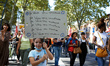 A young girl holds a placard reading 'I want my teacher, I want my teacher, ...' Teachers...