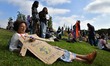 A protester holds a banner while resting during a rally and subsequent march for environme...