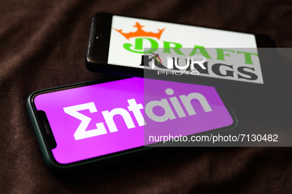 Entain and DraftKings logos displayed on phone screens are seen in this illustration photo taken in Krakow, Poland on September 25, 2021. 