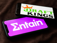 Entain and DraftKings logos displayed on phone screens are seen in this illustration photo taken in Krakow, Poland on September 25, 2021. (
