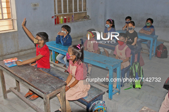 Primary section students wearing protective face mask attend their class after the Rajasthan government allowed schools to reopen for 1st to...