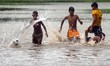 Boys play Football during ground water luggage’s   under heavy rain from Cyclone Komen in...