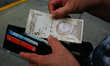 A man keeps a new 5 bolivar banknote in his wallet after withdrawing it from an ATM, amid...