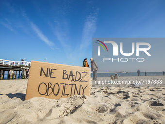 Protesters in front of 'do not be indifferent' banner are seen in Sopot, Poland on 10 October 2021  People protest under the slogan: Don't t...