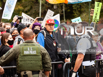 US Park Police guard a barricade while Native American activists and allies await arrest during a protest at the White House against the con...