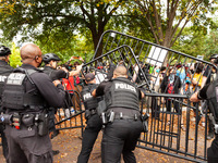 Secret Service police push to hold a barrier against Native American demonstrators angry that their rough handling of a woman under arrest....
