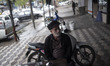 An Iranian man who does not wear protective face mask looks on as he sits in an outdoor ca...