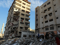 Workers remove rubble of a building destroyed by an Israeli air strike during the May 2021 conflict between Israel and Hamas in Gaza City, o...