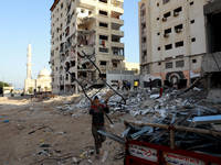 Workers remove rubble of a building destroyed by an Israeli air strike during the May 2021 conflict between Israel and Hamas in Gaza City, o...