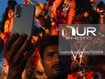 A Hindu devotee takes selfie  with a clay idol of the Hindu Goddess Durga on the last day of Durga Puja Festival, on October 15, 2021 in Bar...