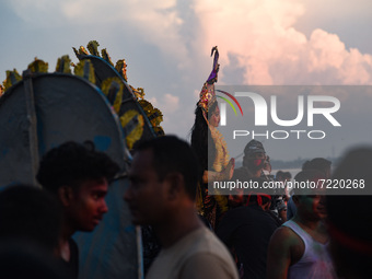 Hindu devotees immerse a clay idol of the Hindu Goddess Durga in a river on the last day of Durga Puja Festival, on October 15, 2021 in Barp...