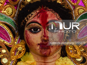 Hindu devotees immerse a clay idol of the Hindu Goddess Durga in a river on the last day of Durga Puja Festival, on October 15, 2021 in Barp...