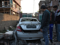 Kashmiri people assess the damaged vehicle near the gun battle site in Pampore area of Pulwama district south of Srinagar, Indian Administer...