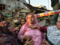 Kashmiri women console the members of damaged residential house near the gun battle site in Pampore area of Pulwama district south of Srinag...