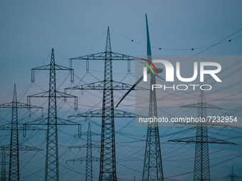 Electricity transmission pylons and a wind turbineare seen in Wesseling, Germany on Oct 17, 2021 (