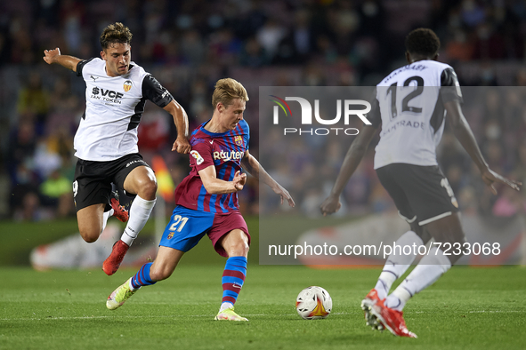 Frenkie de Jong of Barcelona and Maxi Gomez of Valencia compete for the ball during the La Liga Santander match between FC Barcelona and Val...