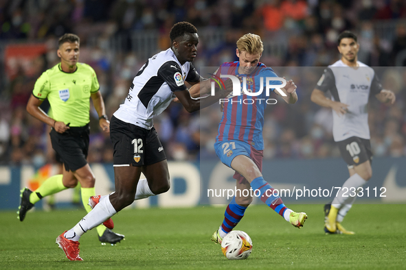 Frenkie de Jong of Barcelona and Mouctar Diakhaby of Valencia compete for the ball during the La Liga Santander match between FC Barcelona a...