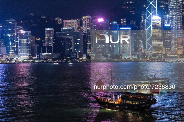 A tour junk crosses a star ferry on Victoria Harbour at night, in Hong Kong, China, on October 17, 2021. 