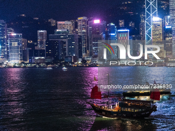 A tour junk crosses a star ferry on Victoria Harbour at night, in Hong Kong, China, on October 17, 2021. (