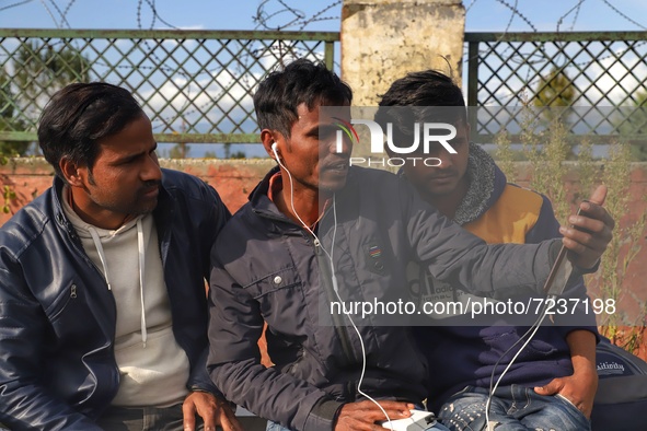 Indian migrant workers speaking during a phone call as they wait with their belongings at a railway station to board trains to their home st...